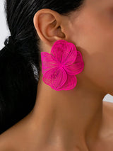 Close-up of a person wearing a bright pink floral earring.
