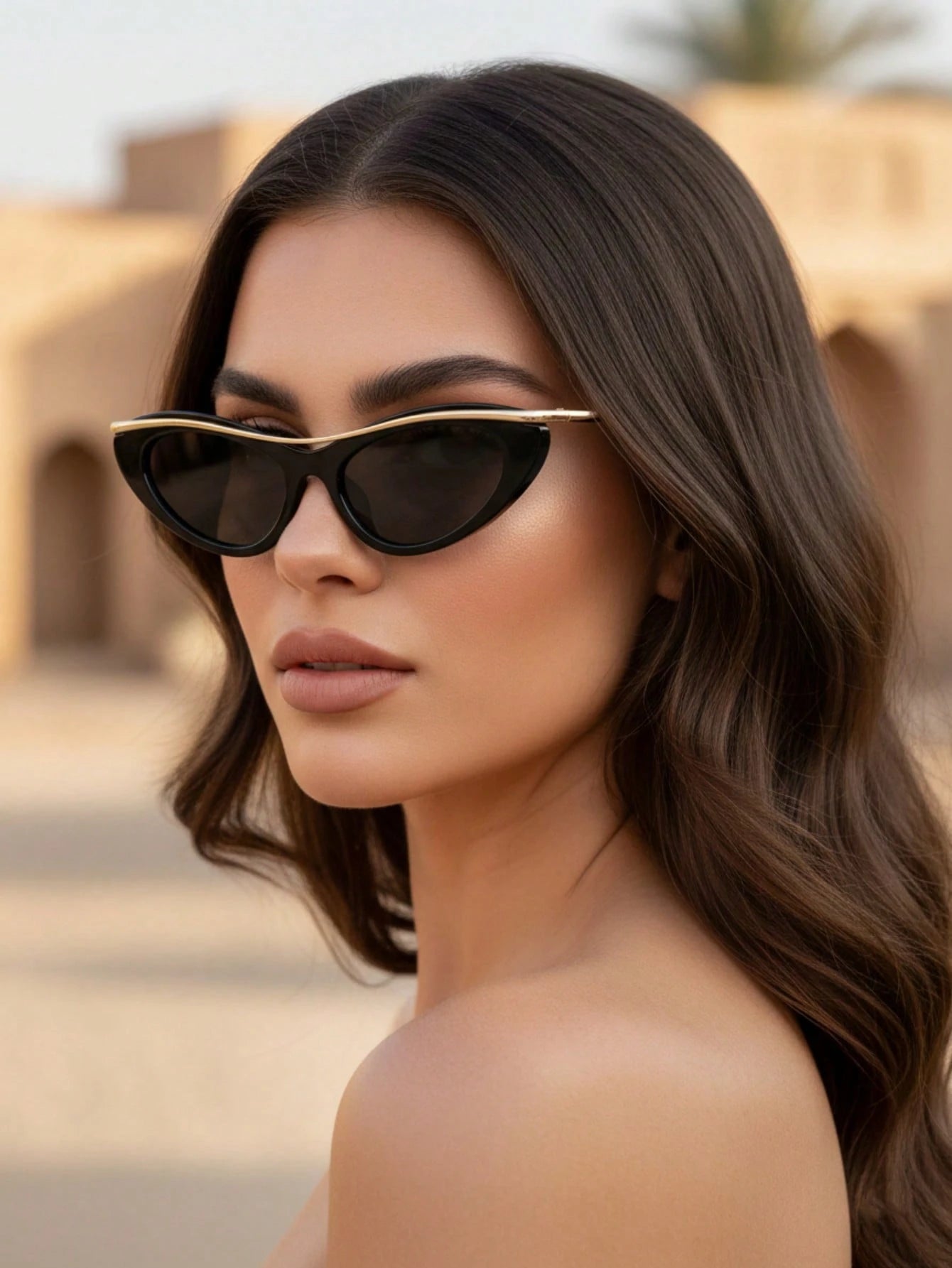 Woman wearing black cat-eye sunglasses with a blurred background