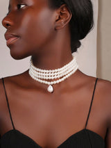 Woman wearing a pearl necklace against a neutral background