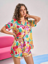 Woman wearing a colorful fruit patterned pajama set against a plain background