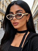Woman wearing leopard print sunglasses and a black outfit in an urban setting
