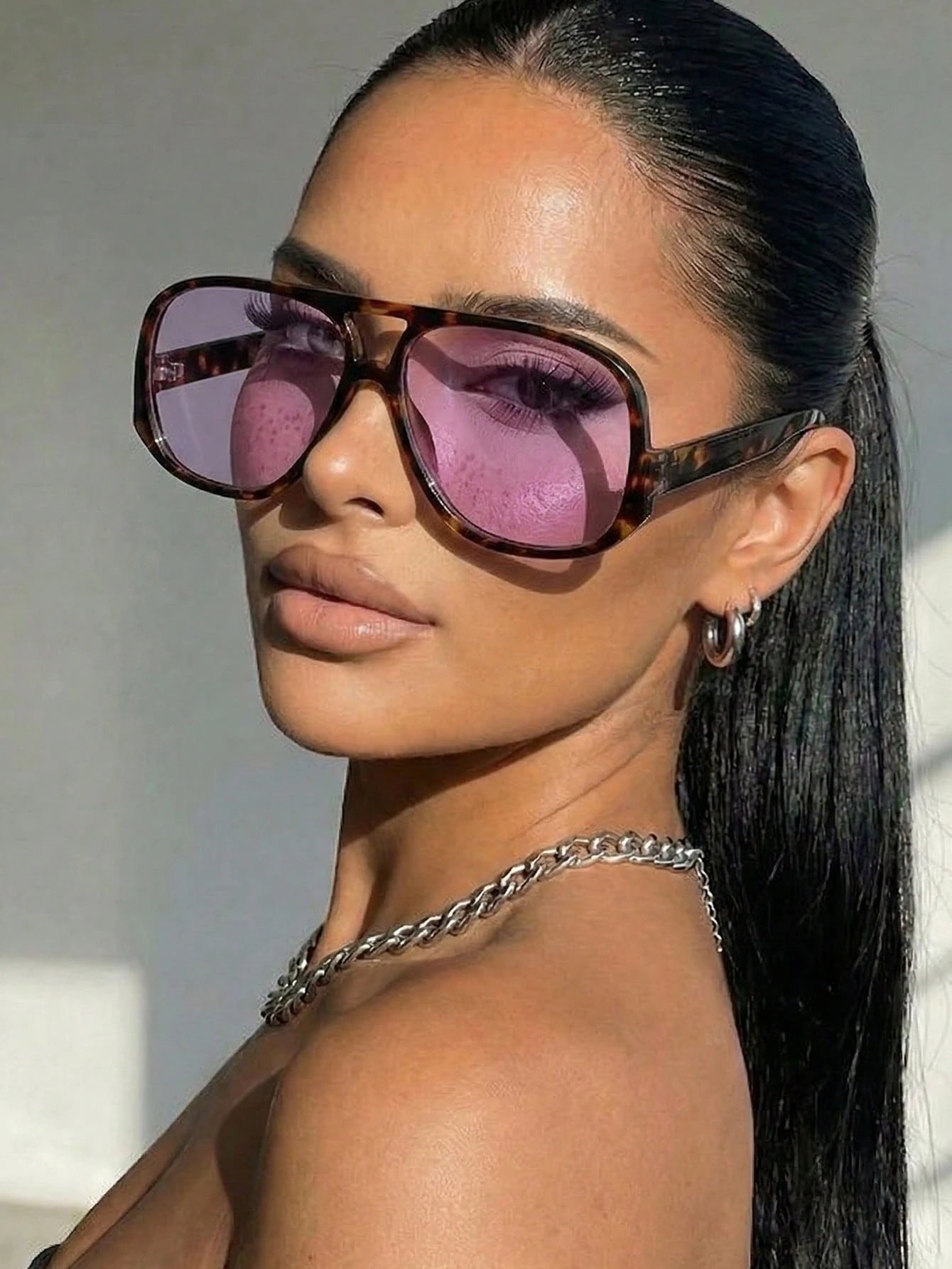 Woman wearing large sunglasses with a blurred background