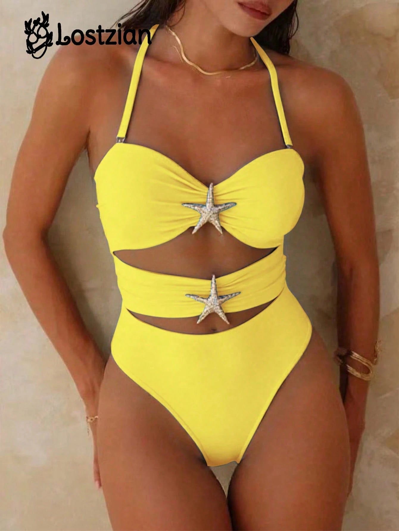 Woman wearing a yellow swimsuit with starfish designs on a beige background
