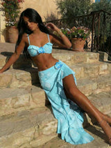 Woman in a blue outfit sitting on stone steps outdoors