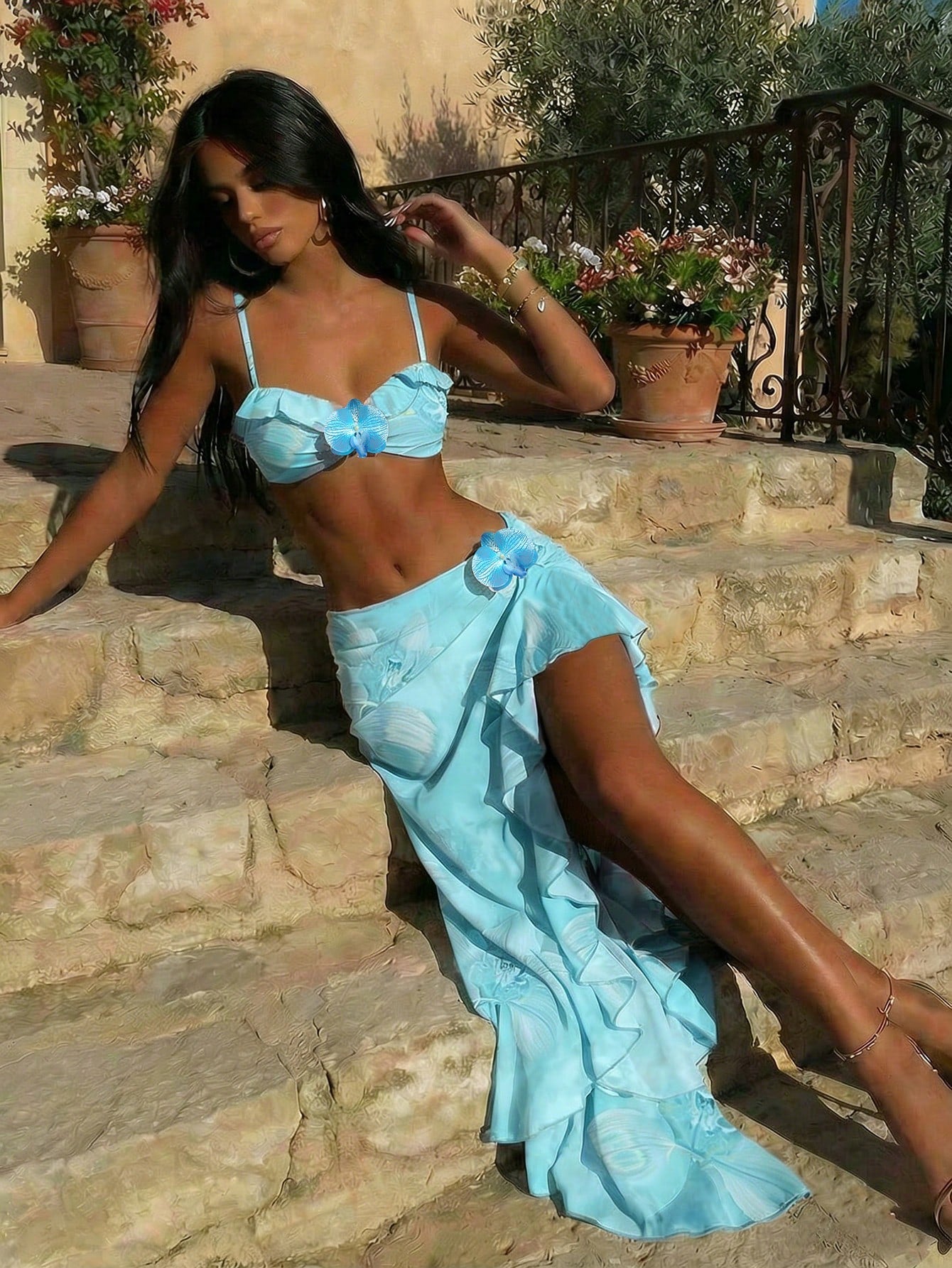 Woman in a blue outfit sitting on stone steps outdoors