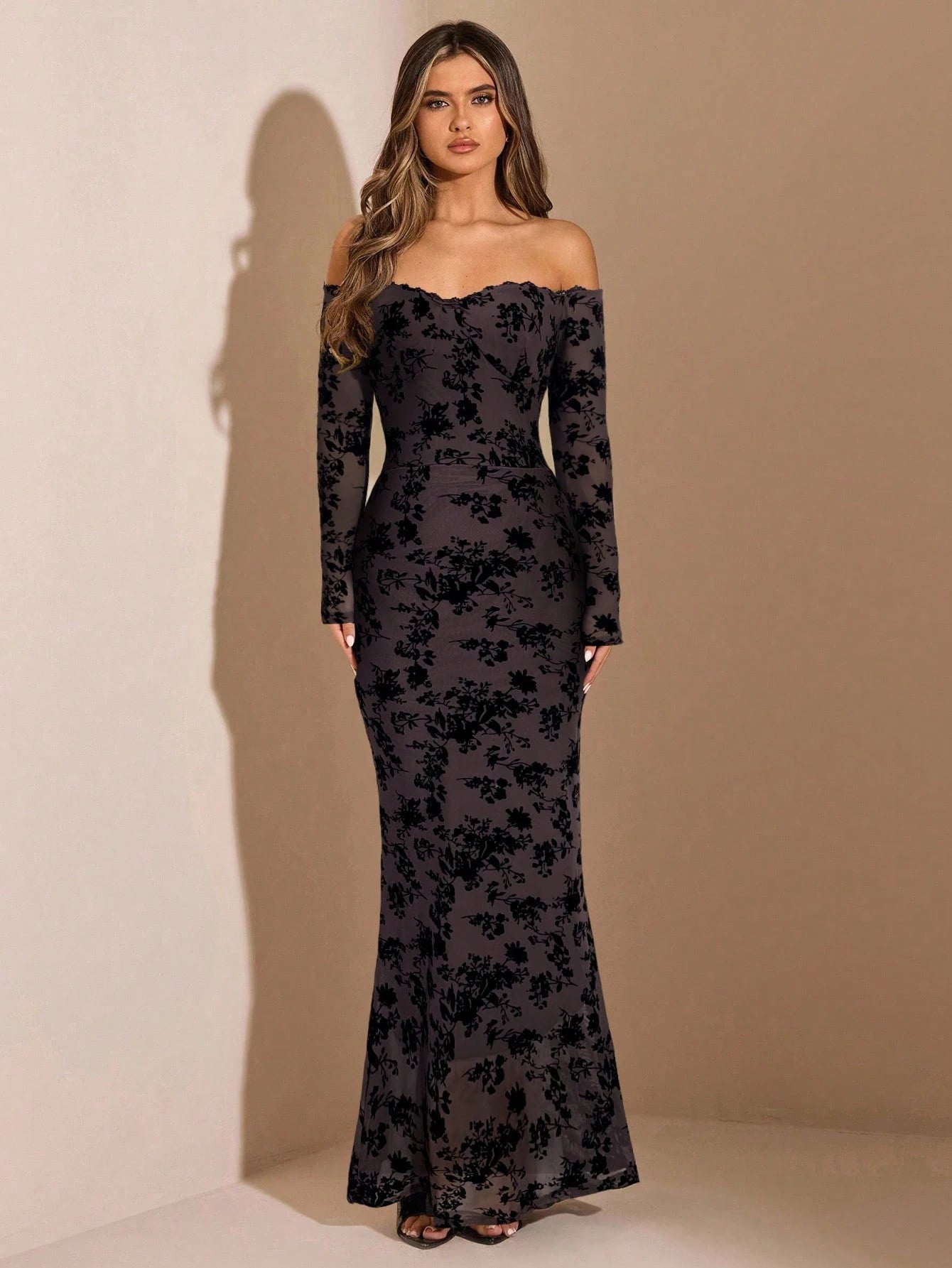 Woman wearing a black floral off-shoulder gown against a beige background