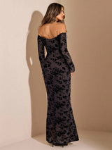 Woman wearing a black floral off-shoulder gown against a beige background