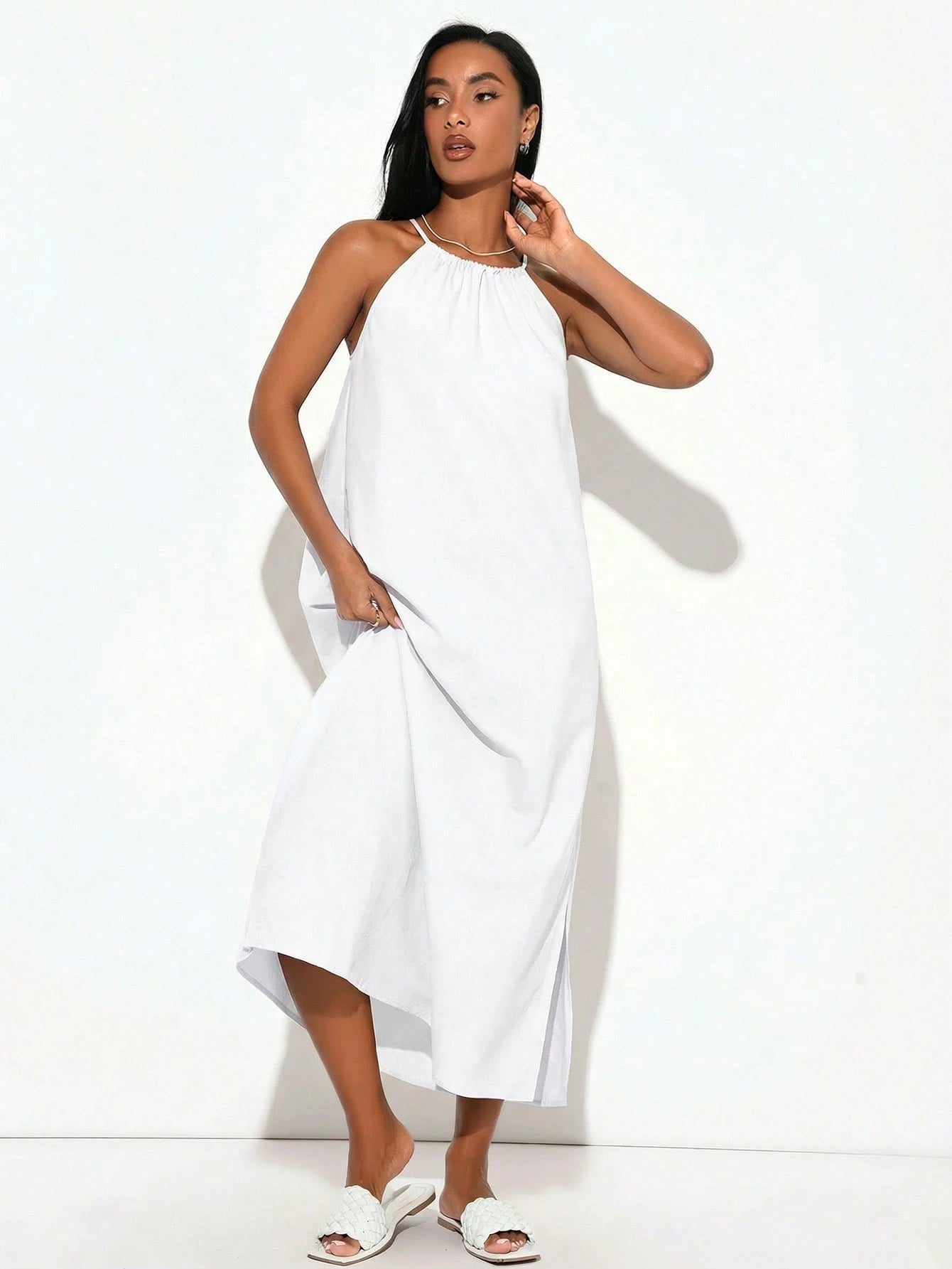 Woman wearing a white halter neck dress on a white background
