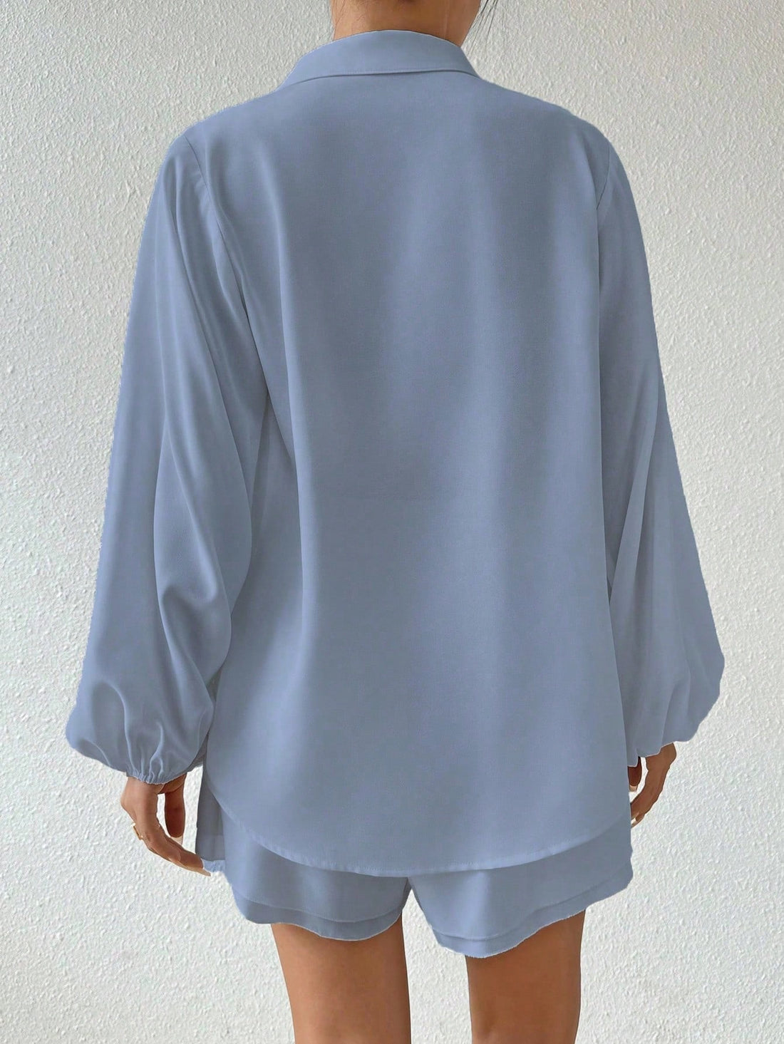 Person wearing a light blue pajama set against a white background