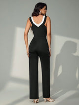 Woman wearing a black and white jumpsuit against a gray background