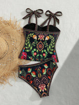 Floral patterned swimsuit with decorative bows on a light background