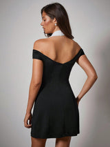 Woman wearing a black off-shoulder dress against a gray background