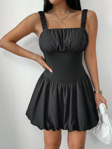 Woman wearing a black dress with a plain background
