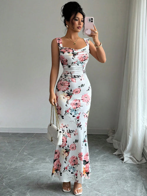 Woman taking a mirror selfie wearing a floral dress in a room with a white curtain.