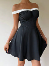 Black off-shoulder dress with white trim on a plain background