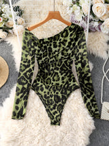 Green leopard print bodysuit on a hanger with decorative background