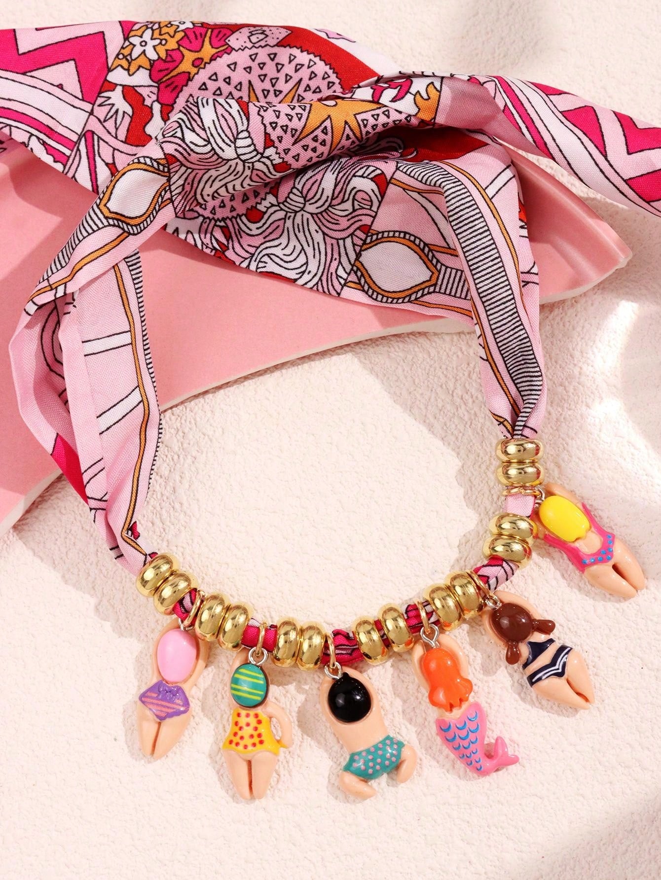 Colorful beaded bracelet with charms on a pink scarf