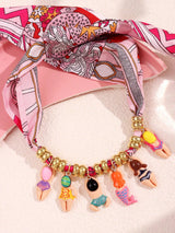 Colorful beaded bracelet with charms on a pink scarf