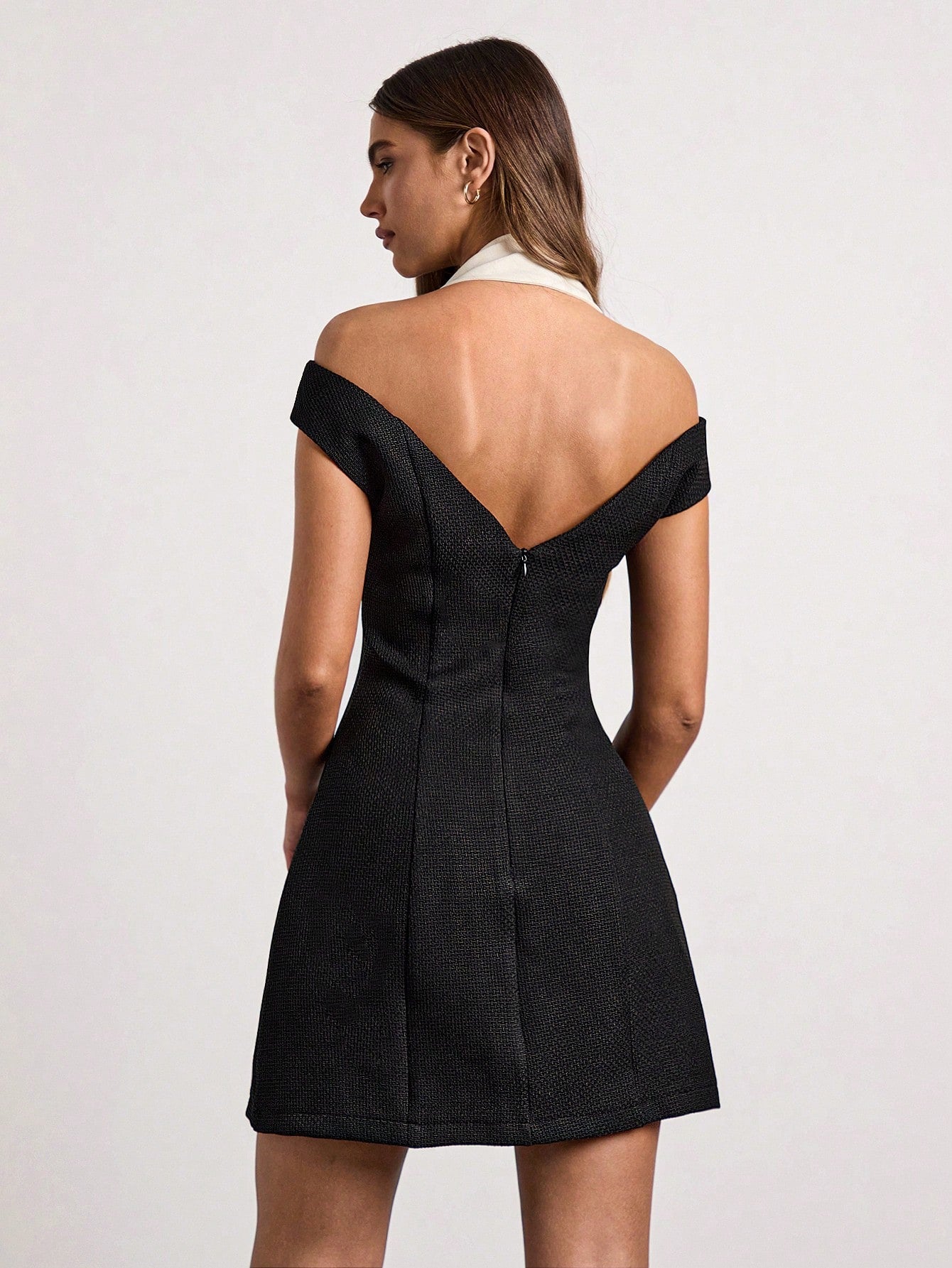 Black off-shoulder dress worn by a model on a white background