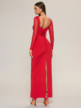 Red evening gown with long sleeves and open back on a plain background