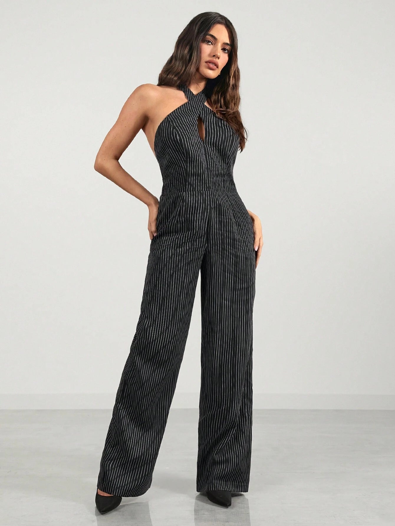 Woman wearing a black and white striped jumpsuit on a white background