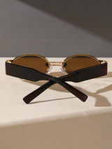 Sunglasses with black frame and brown lenses on a light surface with a dark background