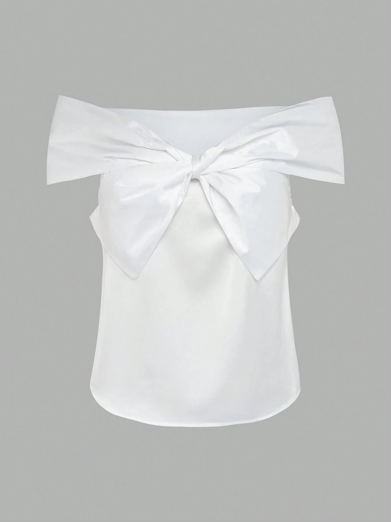 White off-shoulder top with a large bow on a gray background