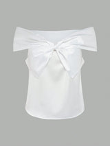 White off-shoulder top with a large bow on a gray background
