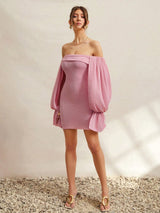 Woman wearing a pink off-shoulder dress against a neutral background