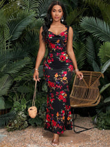 Woman in a floral dress standing in front of green foliage