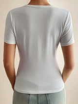 White t-shirt worn by a person on a beige background