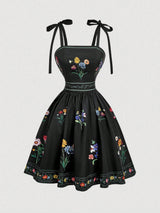 Black dress with floral embroidery on a white background