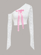 White lace top with a pink ribbon on a gray background