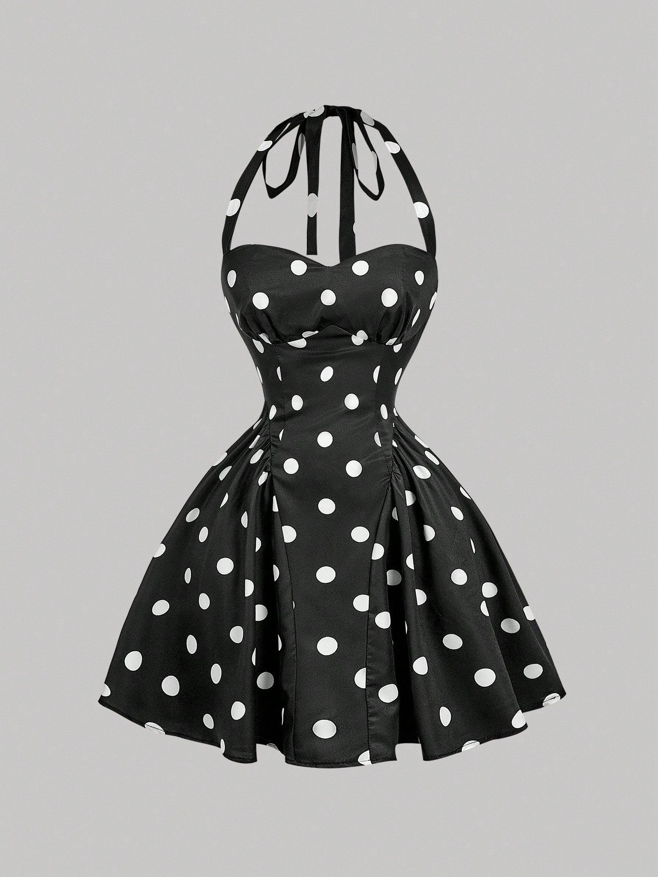 Black dress with white polka dots on a gray background