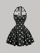 Black dress with white polka dots on a gray background