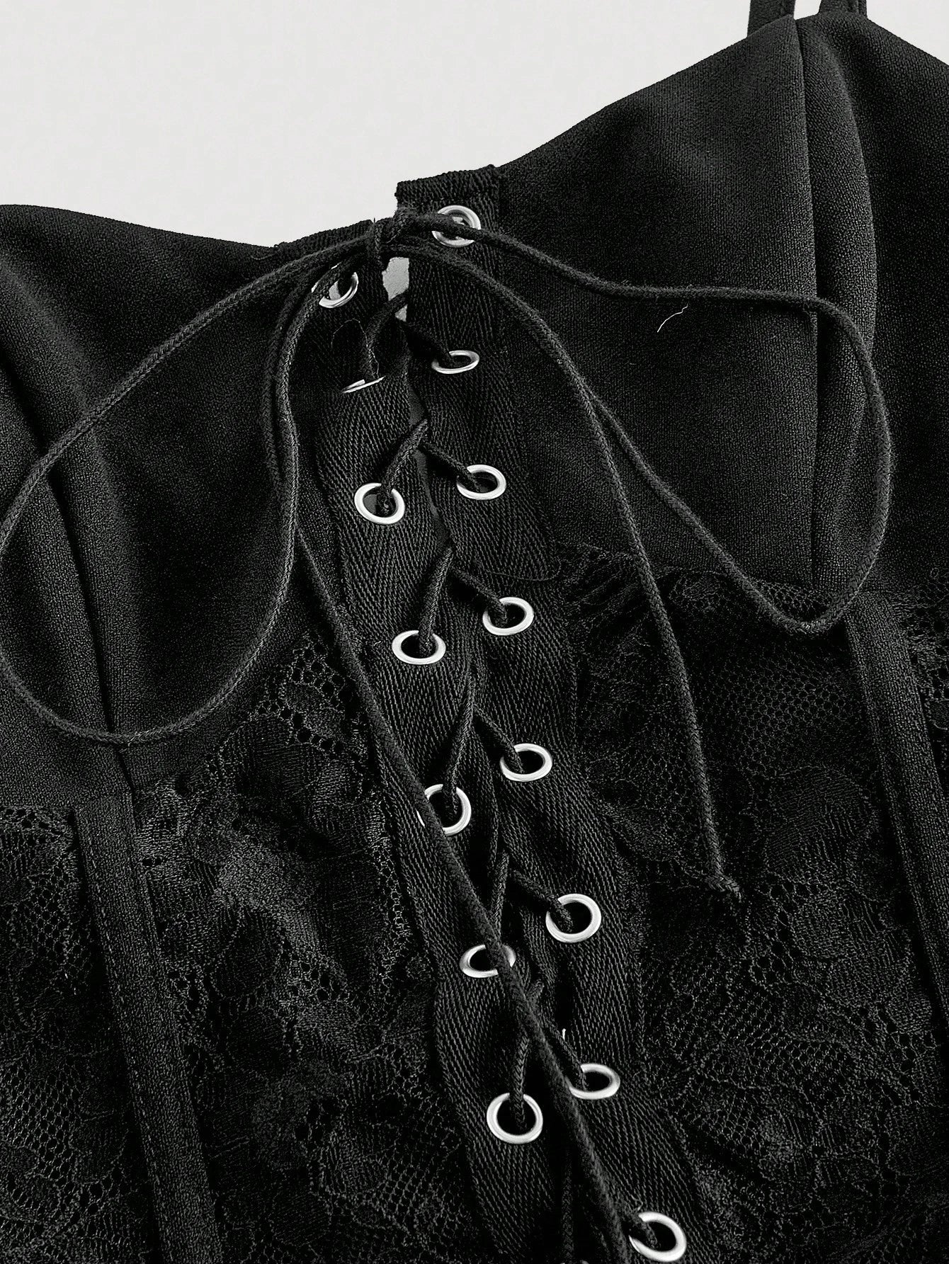 Black lace-up garment with detailed design on a white background