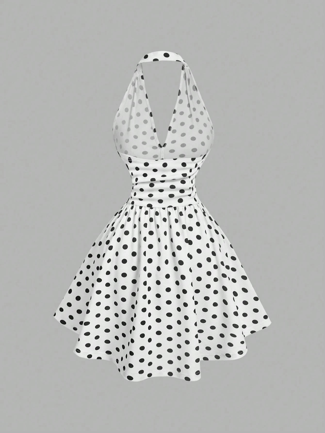 White dress with black polka dots on a gray background