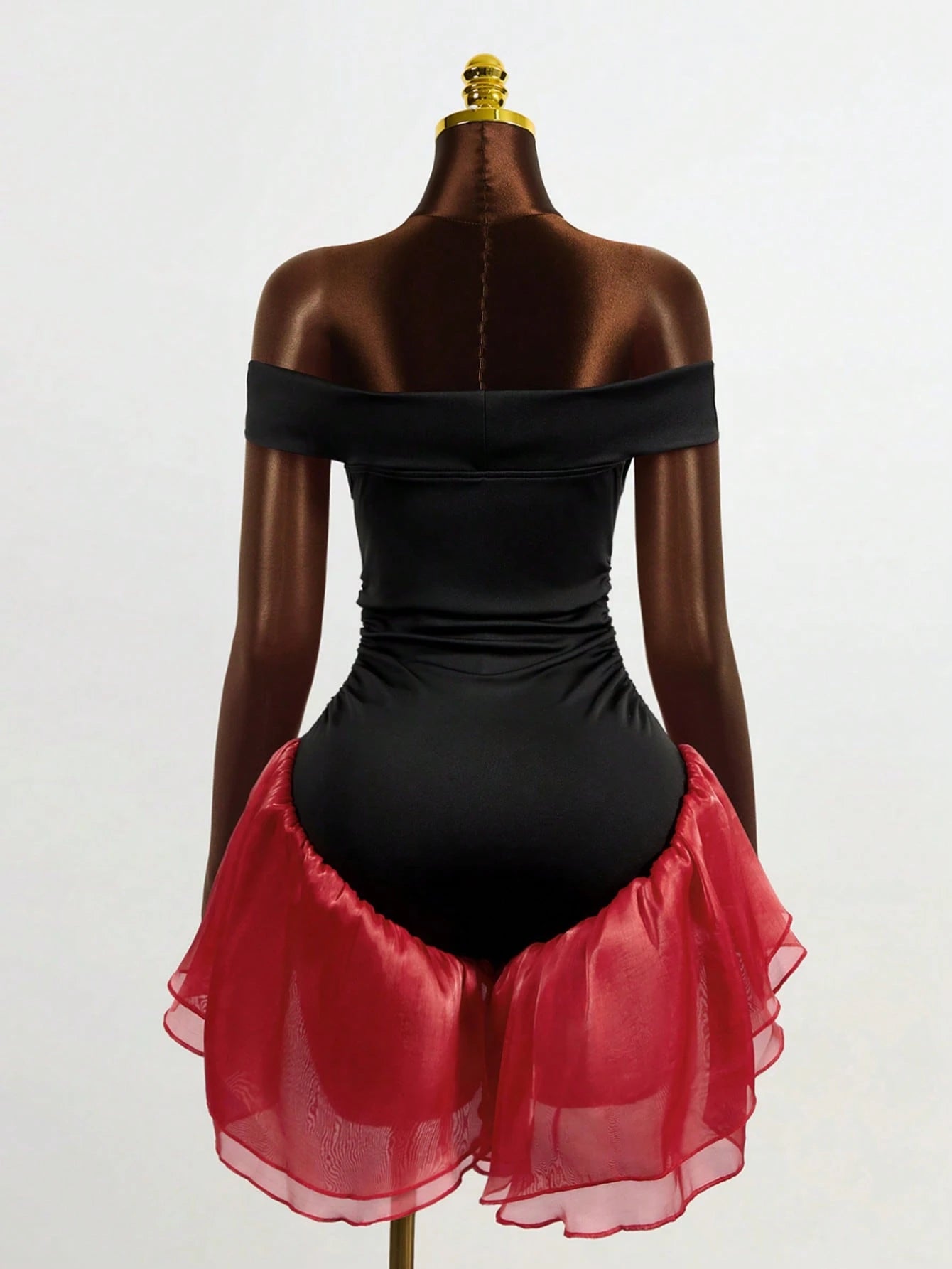 Black bodysuit with red petticoat on a mannequin against a white background