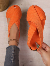 Orange sandals being worn with a neutral background