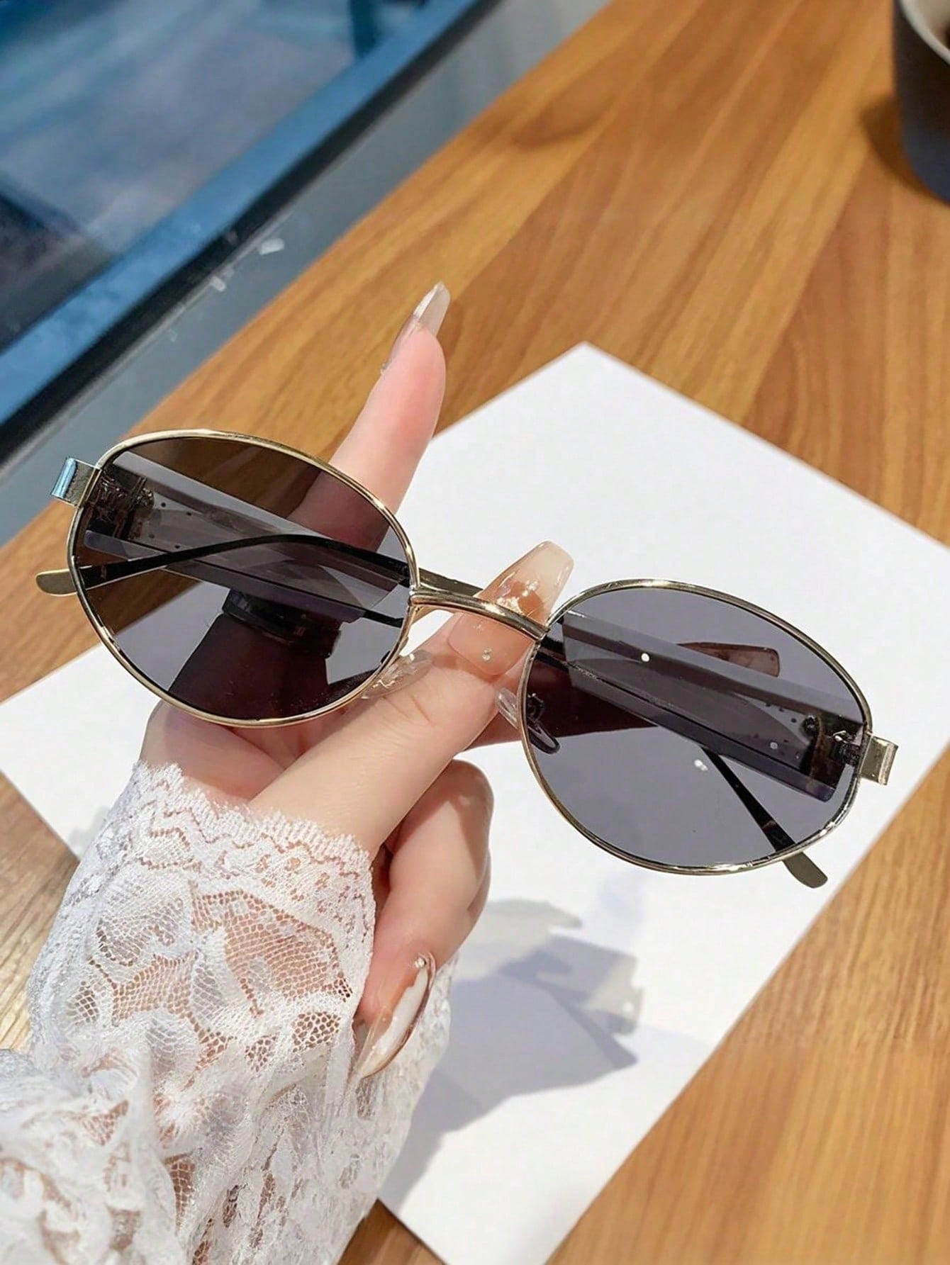 Sunglasses held by a hand with a blurred background