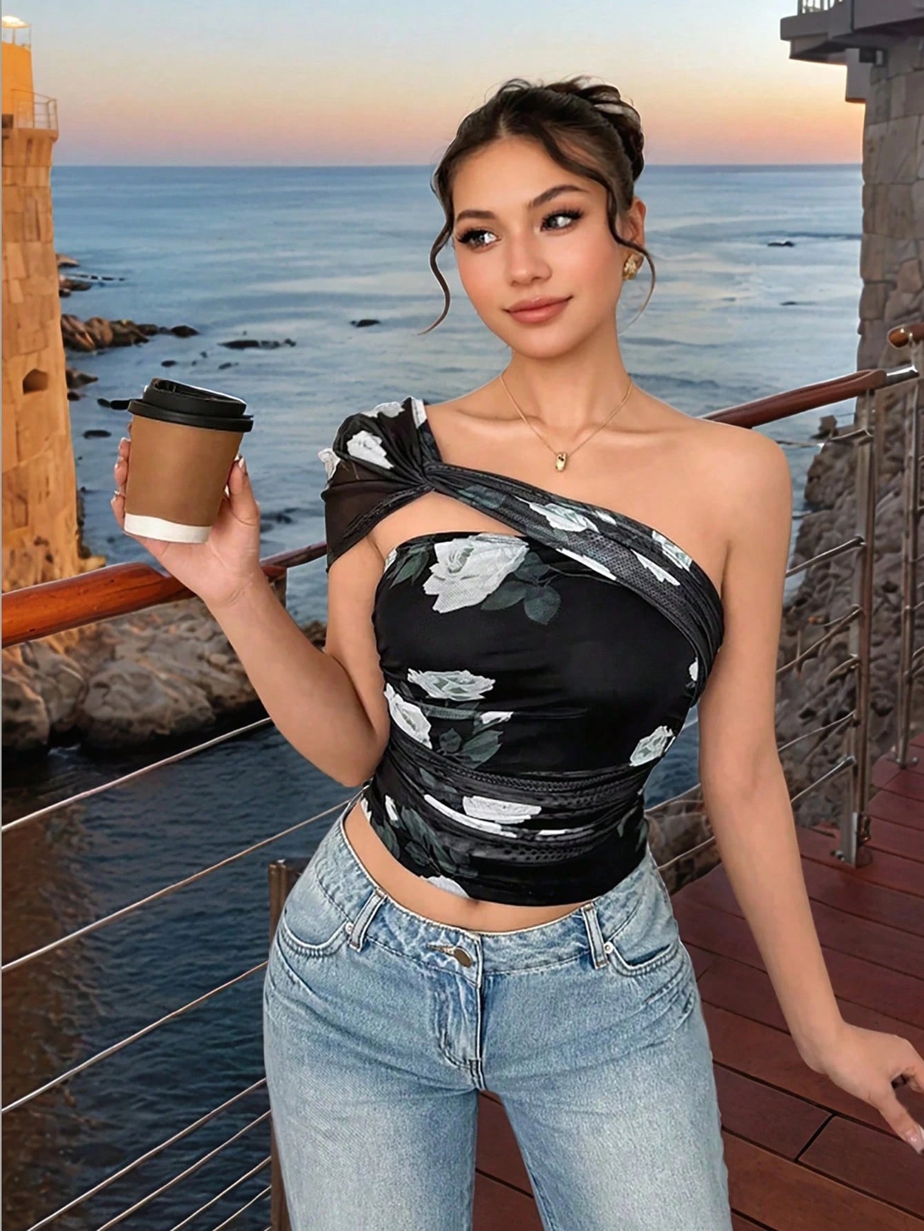 Woman holding a coffee cup by the ocean with a scenic background