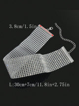 Silver mesh clutch bag with chain strap on a black background