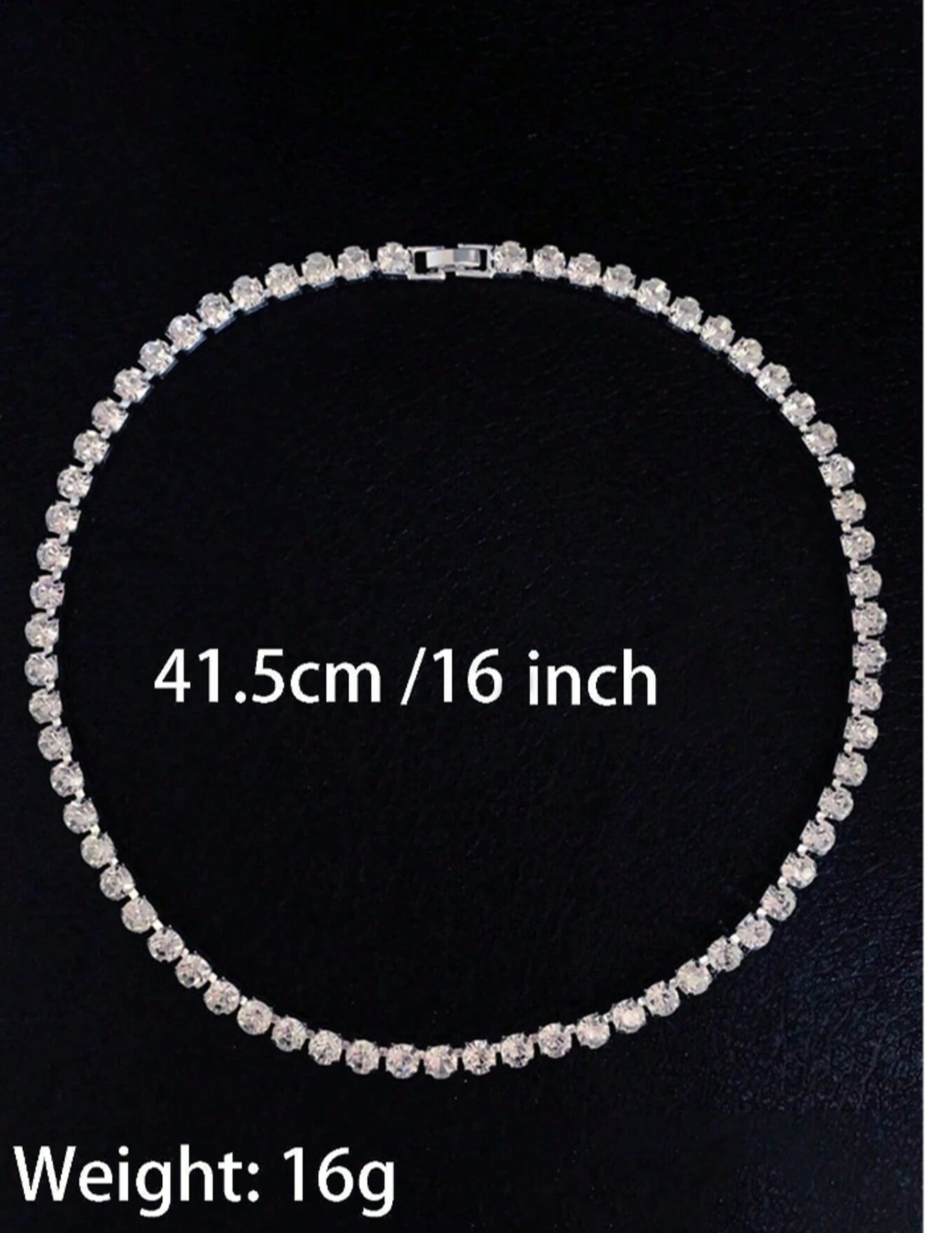Silver necklace with measurement text on a black background