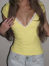 Person wearing a yellow top with lace trim and light blue jeans.