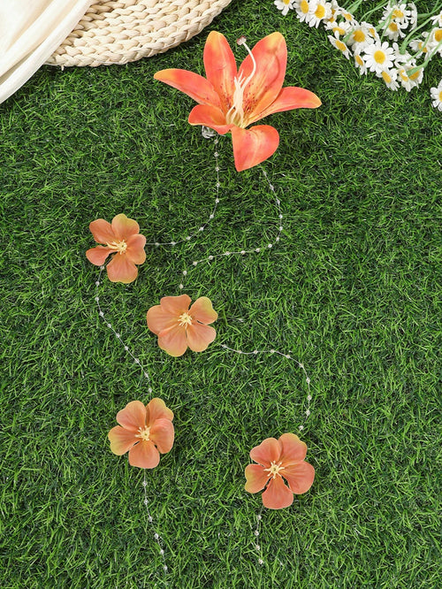 Decorative floral string lights on grass with a woven basket and flowers in the background