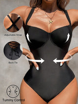 Black bodysuit with adjustable strap and back tie features, on a neutral background.
