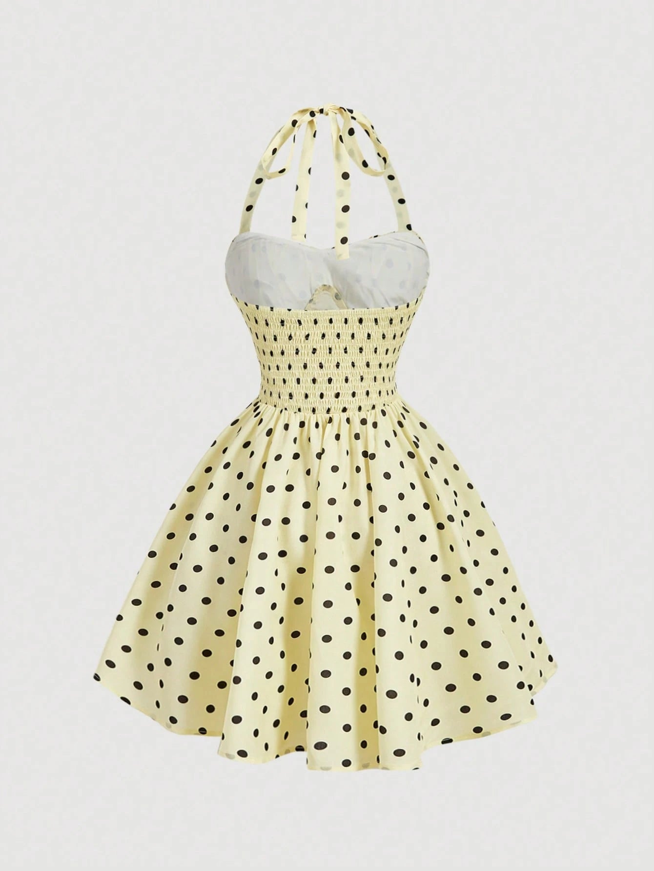Yellow dress with black polka dots on a light gray background
