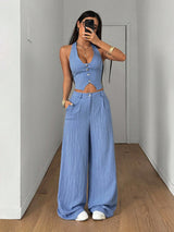 Woman wearing a blue outfit taking a mirror selfie in a room with wooden flooring.