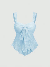 A light blue textured lace top with wide shoulder straps, a sweetheart neckline, and a large front bow, shown against a plain light gray background.