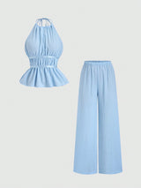 Light blue jumpsuit with halter top and wide-leg pants on a light gray background